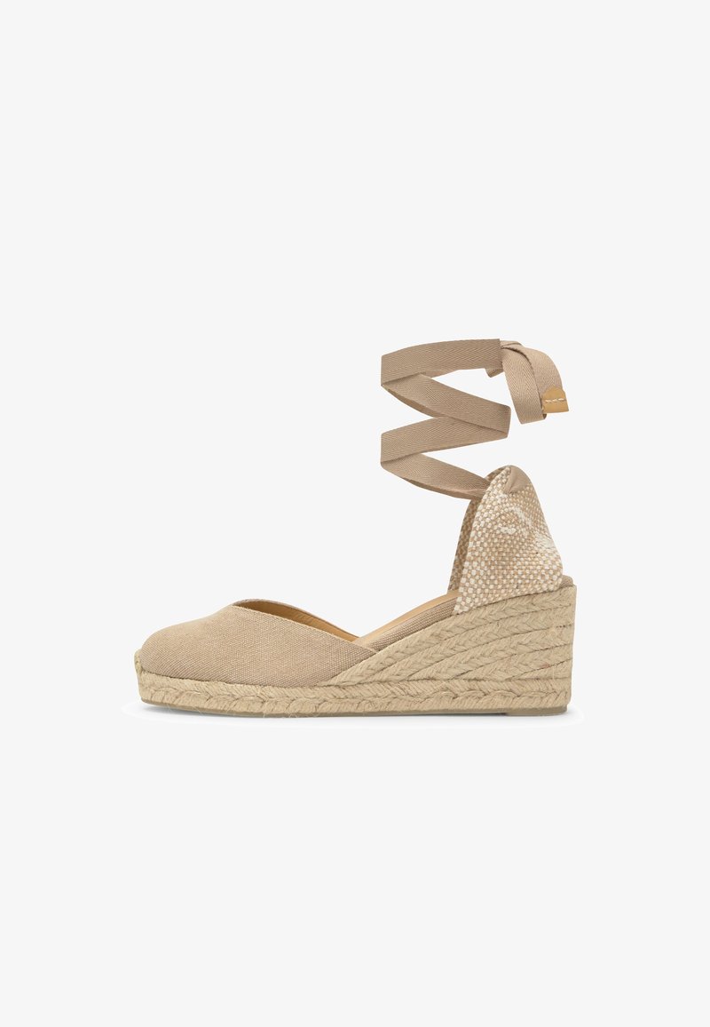 Espadrille beige à talon compensé avec bout fermé, sangle tressée enroulée autour de la cheville et semelle plateforme en jute tressé.