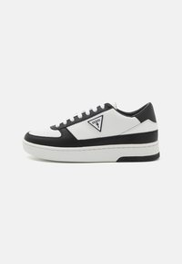 Sneaker bianca e nera realizzata in pelle e materiali sintetici, punta rotonda, suola spessa e logo triangolare sul lato esterno.