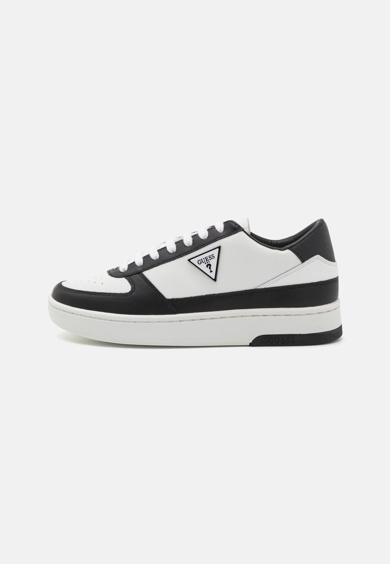 Sneaker bianca e nera realizzata in pelle e materiali sintetici, punta rotonda, suola spessa e logo triangolare sul lato esterno.