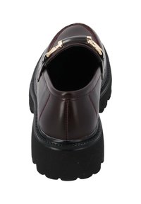 Scarpa slip-on bordeaux con finitura lucida in vernice, accento in hardware dorato e spessa suola in gomma nera. L'interno presenta una fodera liscia.