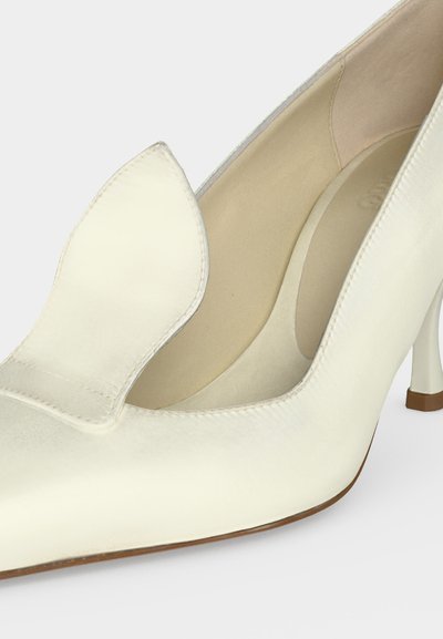 Λευκό γυναικείο παπούτσι με ψηλό τακούνι, μυτερή μύτη και διακοσμητική λεπτομέρεια με πτερύγιο, λεία υφή δέρματος, μπεζ εσωτερική επένδυση και καφέ άκρη σόλας.