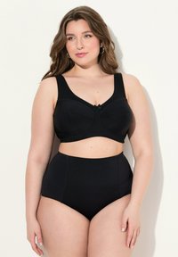 Zwart lingerieset met een getextureerde bralette met brede bandjes en hoge taille shorts, beiden met een subtiel patroon en decoratief strikje.