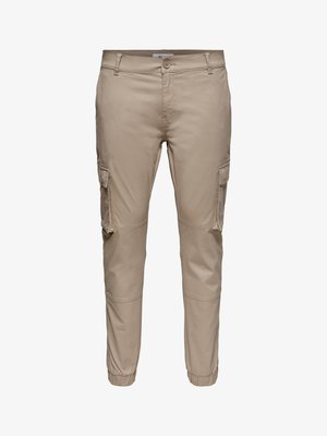 Bež ožje cargo hlače z bočnimi žepi s poklopcem, zapiranjem na gumbe, zanke za pas in elastičnimi manšetami na gležnjih.