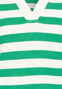 Zöld és fehér csíkos kötött pulóver; V-nyakú dizájn, texturált anyag és egyenletesen elhelyezett vízszintes csíkok jellemzik.