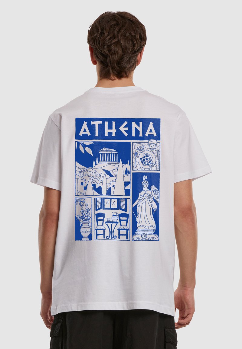 Personne portant un t-shirt blanc avec des panneaux graphiques bleus représentant un temple grec antique, une statue d'Athéna, de la poterie et une scène extérieure.