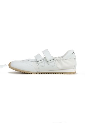 White leather shoe with dual Velcro straps, elasticized collar, pointed toe, and a textured rubber sole, featuring a subtle logo on the back.