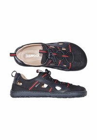 Sandale sportive noire avec des rayures rouges, lacets élastiques réglables, côtés découpés et doublure intérieure beige rembourrée.
