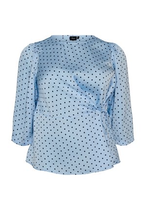 Hellblaue Bluse mit schwarzen Polka-Dots, 3/4-Ärmeln und einer seitlichen Bindung aus strukturiertem Stoff.