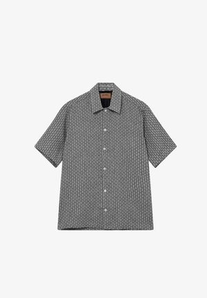 Kurzärmeliges Hemd zum Zuschneiden mit schwarzem und weißem geometrischem Muster und spitzem Kragen, flach auf weißem Hintergrund liegend.