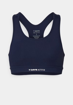 Tamsiai mėlynas sportinis liemenėlė su lenktomis petnešėlėmis. Pagaminta iš tamprios medžiagos, apačioje turi baltą "7 DIENOS AKTYVIAI" logotipą.