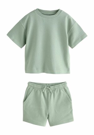 Hellgrünes kurzärmeliges Oberteil mit Rundhalsausschnitt und passende Shorts mit elastischem Bund, Kordelzug und Fronttaschen, flach liegend.