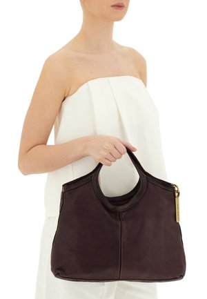 Borsa a mano in pelle marrone scuro con una superficie liscia, manici superiori curvi e dettaglio della zip dorata. Presenta cuciture a contrasto.