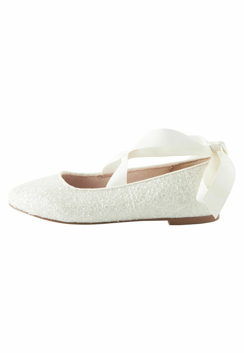 Ballerine blanche pailletée avec rubans à la cheville noués en nœud, petit talon et bout en amande.