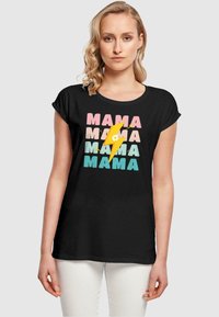 Černé tričko s ohrnutými krátkými ruk�ávy, na kterém je multicolorový design nápisu "MAMA" a grafika s bleskem a květinou.