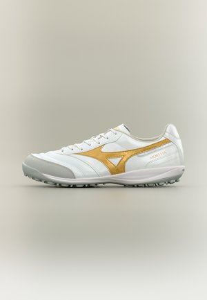 White and gold Mizuno Morelia leather soccer shoe with textured sole and lace-up closure on neutral background.