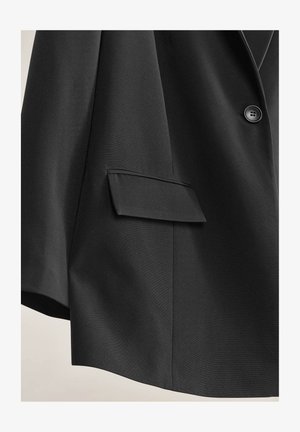 Blazer nero realizzato in tessuto testurizzato, con chiusura a un bottone e tasca a falda sul lato sinistro.