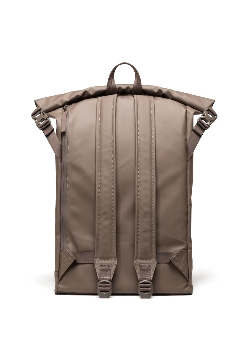 Rolovací batoh v matném béžovém materiálu, vybavený polstrovanými popruhy, horním madlem a dvojitými zipy s nastavitelným kováním pro bezpečné uzavření.