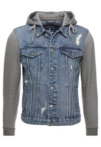 Denimjakke med grå jerseyærmer og hætte, med slidte detaljer, knaplukning og brystlommer. Blå og grå farveskema.