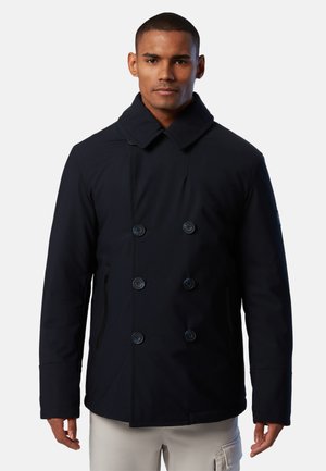 Giacca doppiopetto blu navy con colletto alto, grandi bottoni, tasca laterale con zip e finitura in tessuto texturizzato.