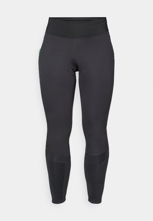 Black leggings with a high waist, made from stretchy fabric. Features a smooth texture, paneling at knees, and minimal branding detail.