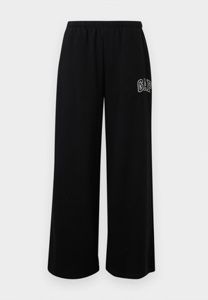 Pantalon de survêtement noir à jambes larges avec taille élastique et logo blanc "GAP" sur la partie supérieure de la cuisse droite.