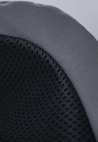 Schwarzes ergonomisches Stuhlkissen mit Mesh-Struktur und einer grauen, glatten Kante. Die Oberfläche zeigt ein feines Muster, das den Grip und den Komfort verbessert.