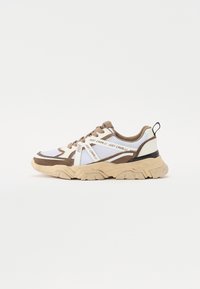 Multimaterial sneakers med et design i mesh og semsket skinn i hvit og brun, tykk beige såle, og merkevaredetaljer på sidene.