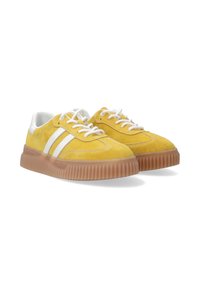 Gelbe Wildledersneaker mit weißen Streifen, runder Zehenpartie und einer dicken transparenten Gummisohle. Schnürsenkel und gepolsterter Kragen in Weiß.