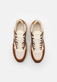 Lightweight sneakers featuring a mix of beige mesh, brown suede, and leather accents, with white laces and a textured rubber sole.
