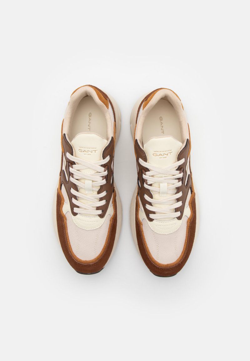 Sneakers leggeri con una combinazione di mesh beige, suede marrone e dettagli in pelle, dotati di lacci bianchi e una suola in gomma testurizzata.