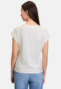 Hvid kortærmet t-shirt med rullede ærmer, der har en afslappet pasform og en glat tekstur. Bagenden viser pæne sømme og subtile designdetaljer.