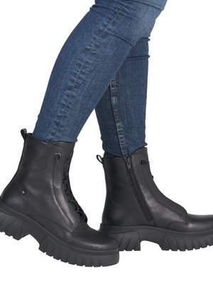 Bottes en cuir noir avec une semelle épaisse, dotées de lacets et d'une fermeture éclair latérale pour un enfilage facile. Le design comprend des accents texturés et un talon robuste.