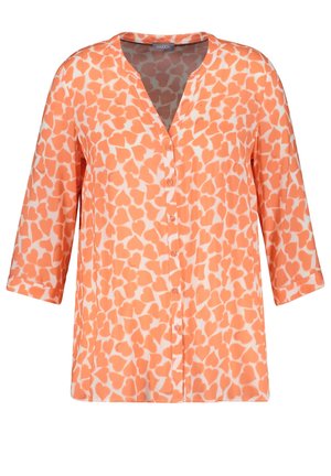 Pomarańczowo-biała bluzka na guziki w serduszka z rękawami 3/4 i dekoltem w serek.