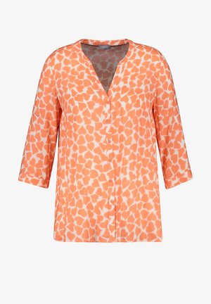 Blusa de botones con estampado de corazones en naranja y blanco, mangas tres cuartos y cuello en V.