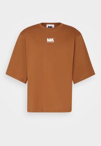 Camiseta oversized marrón hecha de algodón suave. Presenta mangas cortas y un cuello redondo, con un pequeño logo blanco en el pecho.