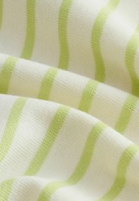 Tissu en jersey de coton avec des rayures alternées de vert clair et de blanc. La texture est douce avec une finition légèrement duveteuse.