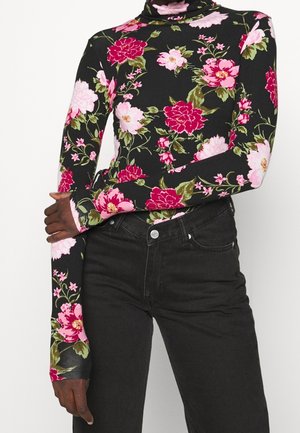 Haut à col roulé à manches longues en noir avec un motif floral rose et vert. Tissu doux avec une coupe ajustée et des poignets allongés.