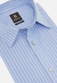 Chemise rayée bleu clair avec une coupe régulière, dotée d'un col classique et de boutons blancs. Le matériau présente une finition douce et texturée.