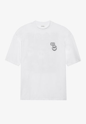 Λευκό βαμβακερό T-shirt με κοντά μανίκια, στρογγυλή λαιμόκοψη και μαύρο γραφικό χαμογελαστού προσώπου με κείμενο στη αριστερή πλευρά του στήθους.