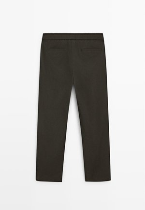 Pantaloni dritti color oliva scuro con vita elasticizzata e due tasche a filetto sul retro, mostrati da dietro su uno sfondo semplice.