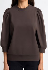 Maglione marrone con maniche a sbuffo, scollo arrotondato e cintura aderente. Texture liscia e tessuto elasticizzato offrono comfort.