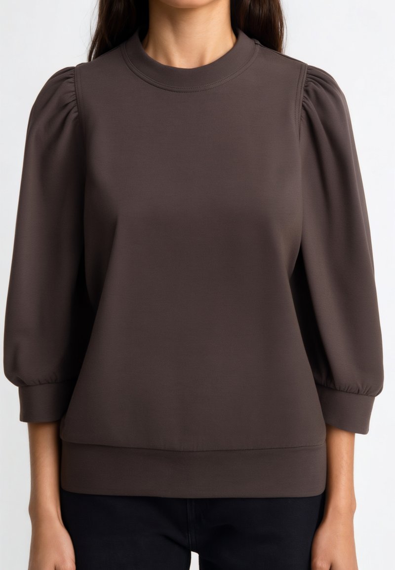 Maglione marrone con maniche a sbuffo, scollo arrotondato e cintura aderente. Texture liscia e tessuto elasticizzato offrono comfort.
