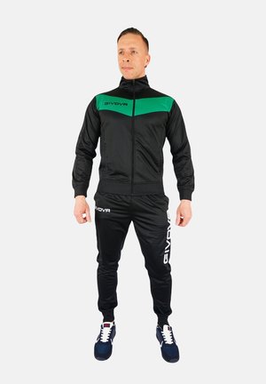 Zwarte trainingsoutfit met een groene accent op de bovenkant, bestaande uit een jack met rits en broek met elastische tailleband. Logo prominent weergegeven.
