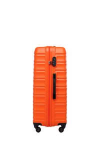Tvrdý kufr v jasně oranžové barvě, s prohnutým designem, pevný černý zip, integrovaný zámek a čtyři kolečka pro snadnou mobilitu.