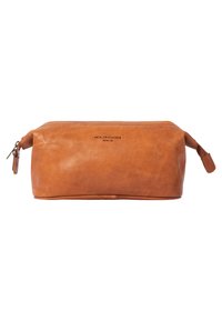 Leather toiletry bag in a rich tan color, featuring a rounded shape, zip closure, and a small handle on one side. Textured surface with branding.