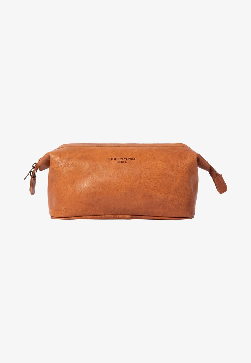 Leather toiletry bag in a rich tan color, featuring a rounded shape, zip closure, and a small handle on one side. Textured surface with branding.