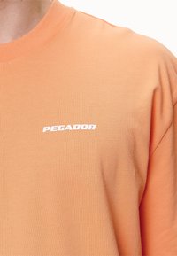 Pegador LOGO TEE - T-Shirt basic - washed apricot/white gum