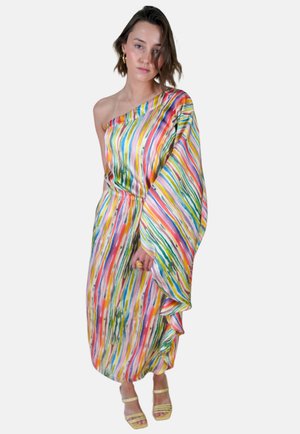 Un mannequin se tient avec confiance dans une robe vibrante multicolore à une épaule. Elle porte des boucles d'oreilles en or et des sandales à lanières.