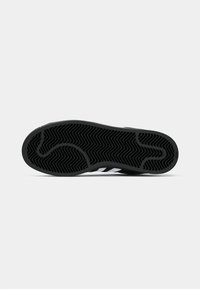 Black rubber sole with a herringbone pattern, featuring three white stripes along the sides, smooth texture, and distinct curved edges.