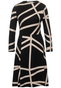Musta mekko pitkillä hihoilla, jossa on kermaisen värinen geometrinen kuvio. Valmistettu pehmeästä kankaasta, siinä on muotoiltu yläosa ja levitettävä hame.